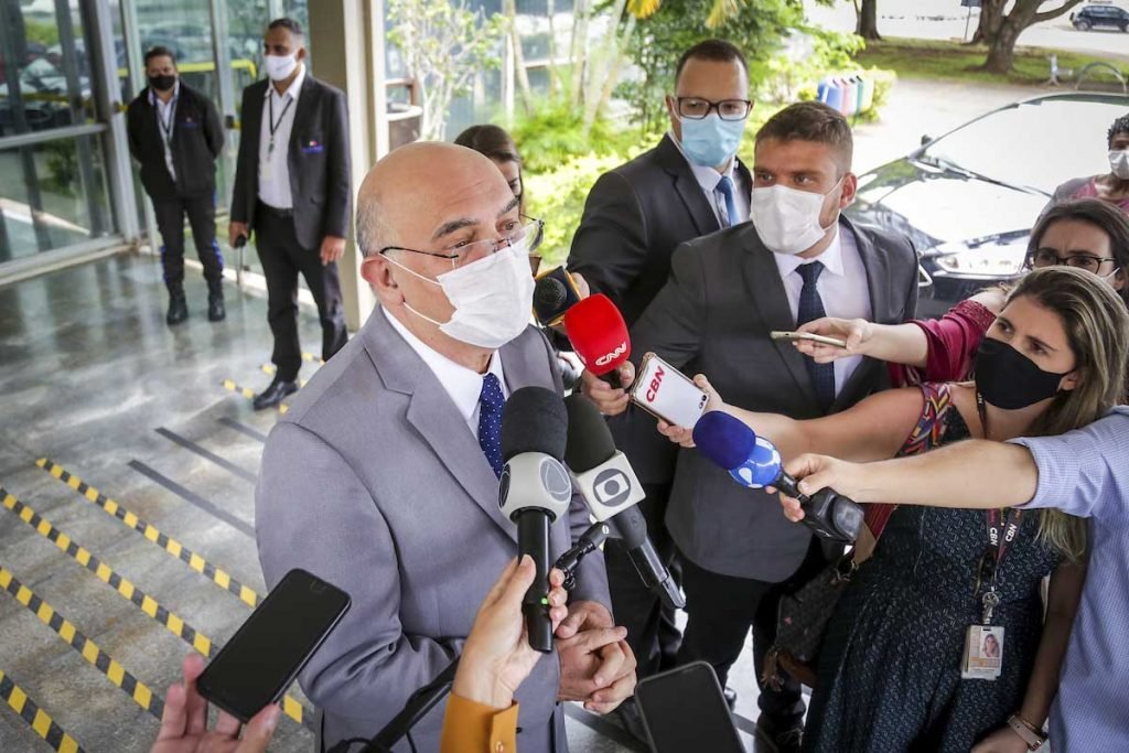 Ministro da Educação, Milton Ribeiro sendo entrevistado em visita novo ministro da Saúde. Ele está em frente à entrada do ministério, de máscara - Metrópoles