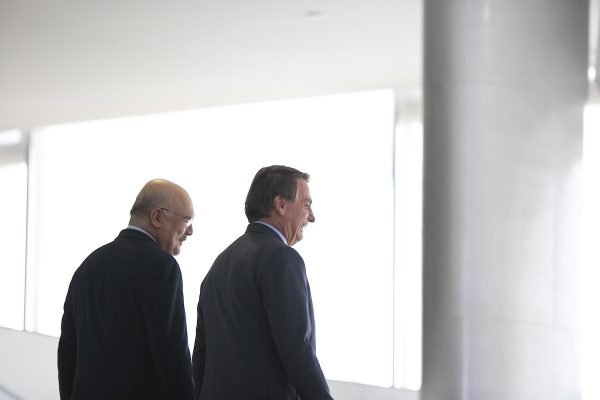 Ministro da Educação, Milton Ribeiro caminha com o presidente Bolsonaro em rampa no Planalto em cerimônia de assinatura do reajuste do piso salarial dos professores do ensino básico. Eles estão de costas - Metrópoles