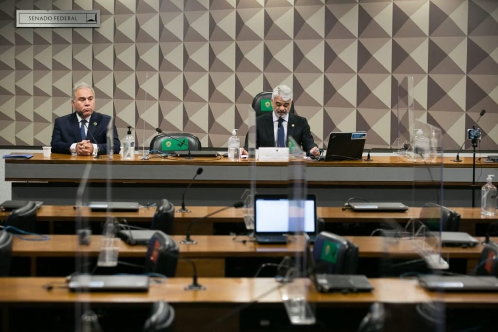 Em sala de comissão no Senado, vê-se fileiras de cadeiras vazias e na mesa da frente o ministro da Saúde Marcelo Queiroga e o senador Humberto Costa, do PT de Pernambuco. Ambos usam terno - Metrópoles
