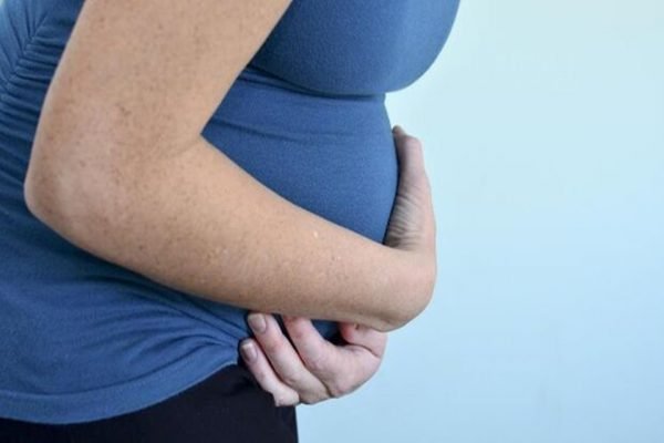 Mulher grávida segurando a sua barriga