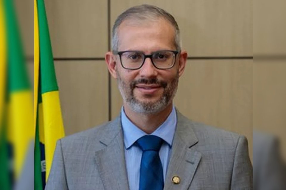 Victor Godoy Veiga, até então secretário-executivo do Ministério da Educação, foi nomeado ministro interno da pasta após a saída de Milton Ribeiro.  Na foto ele sorri, frente à bandeira do Brasil numa sala, e usa terno - Metrópoles