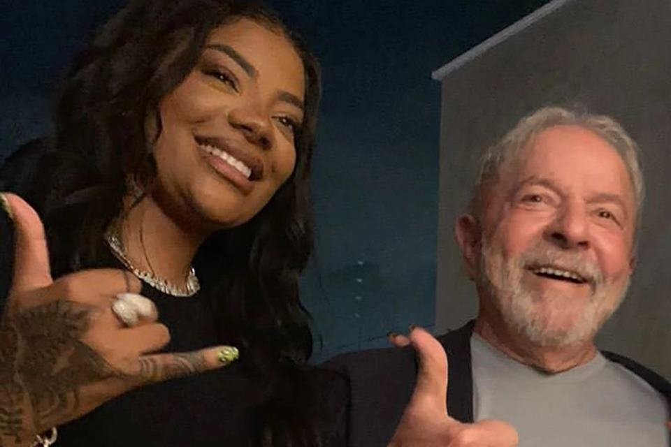 A cantora Ludmilla sorri e faz gesto de