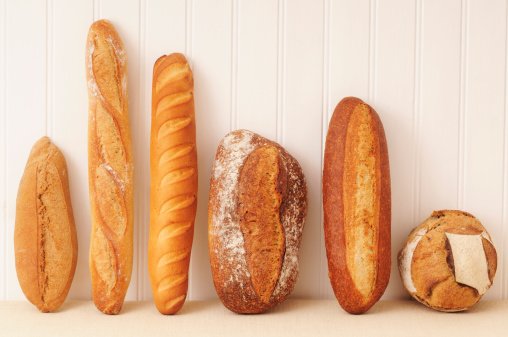 Foto de seis pães em pé encostados na parede