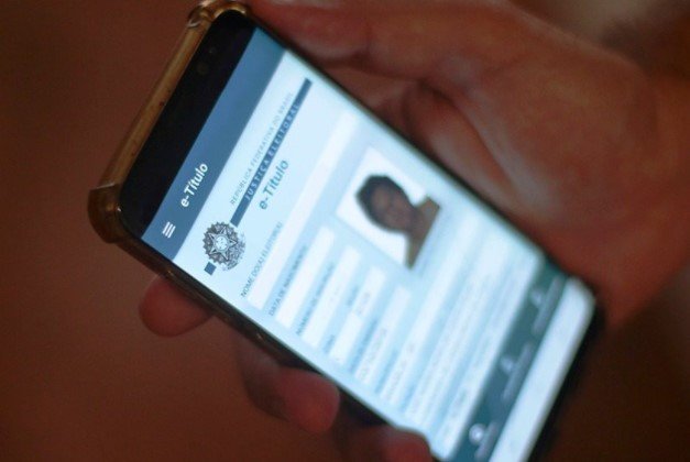 Pessoa segurando um celular com um aplicativo aberto - Metrópoles