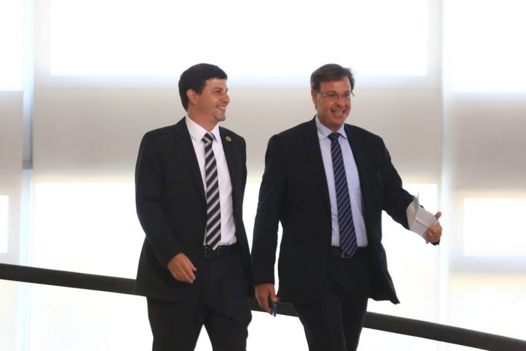 Ex-ministro do Turismo, Gilson Machado, e substituto, Carlos Brito, atual presidente da Embratur descem a rampa do Planalto. Ambos usam terno e o ex-ministro acena - Metrópoles