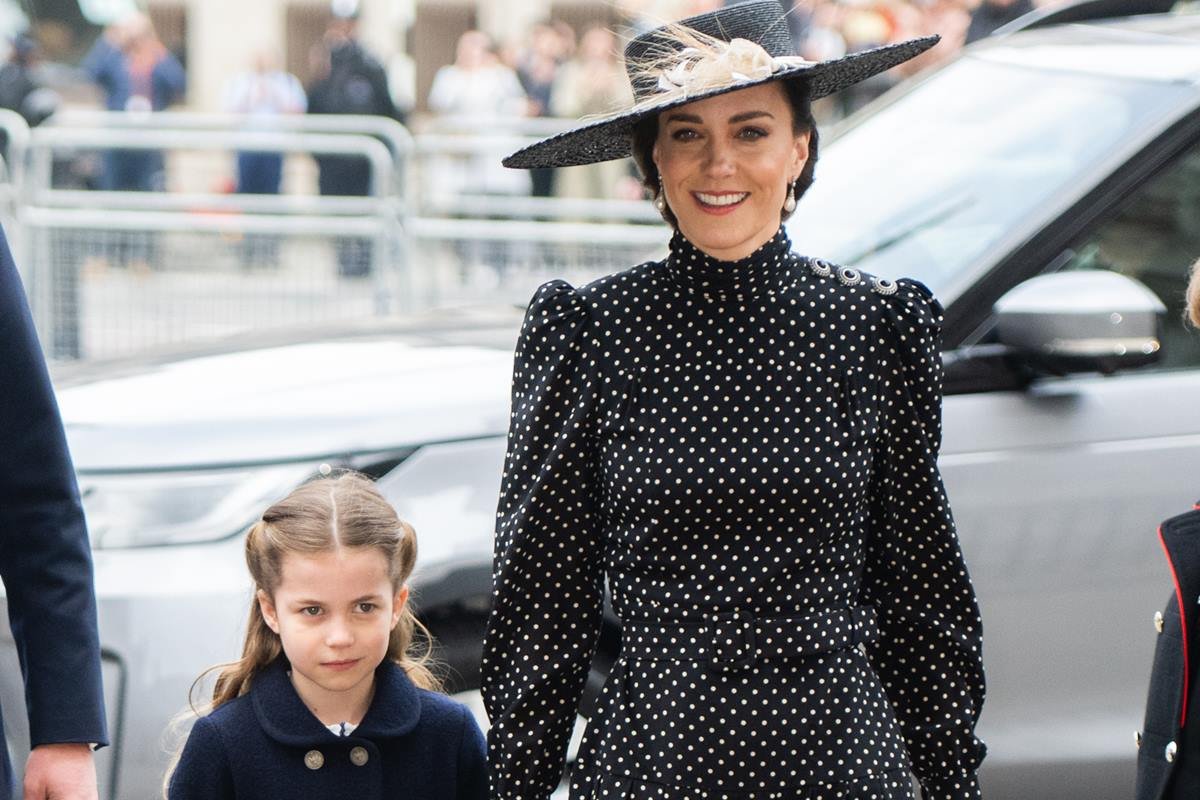 Foto colorida. Princesa Charlotte e Kate Middleton de mãos dadas