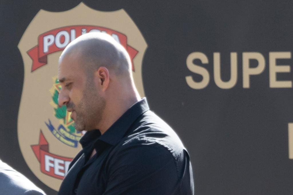 Daniel Silveira sai da PF após colocar tornozeleira eletrônica por determinzação do ministro do STF Alexandre de Moraes. Ele está de lado, frente a fachada do prédio - Metrópoles