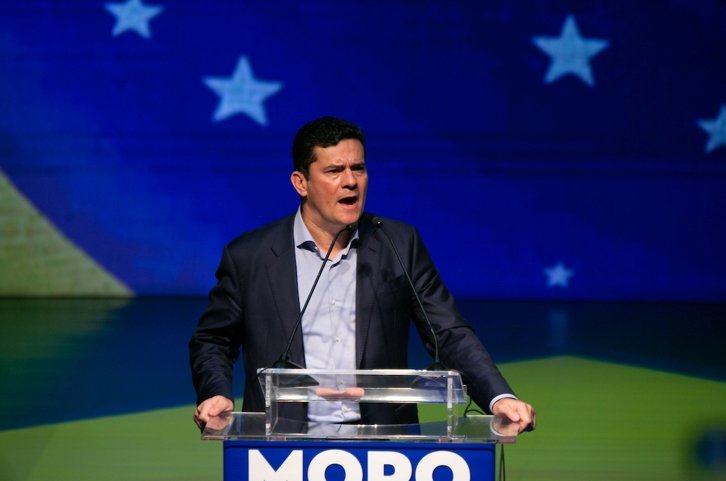 Sérgio Moro em evento de sua filiação ao Podemos, em Brasília. Ele fala em púlpito com microfones com a bandeira do Brasil ao fundo - Metrópoles