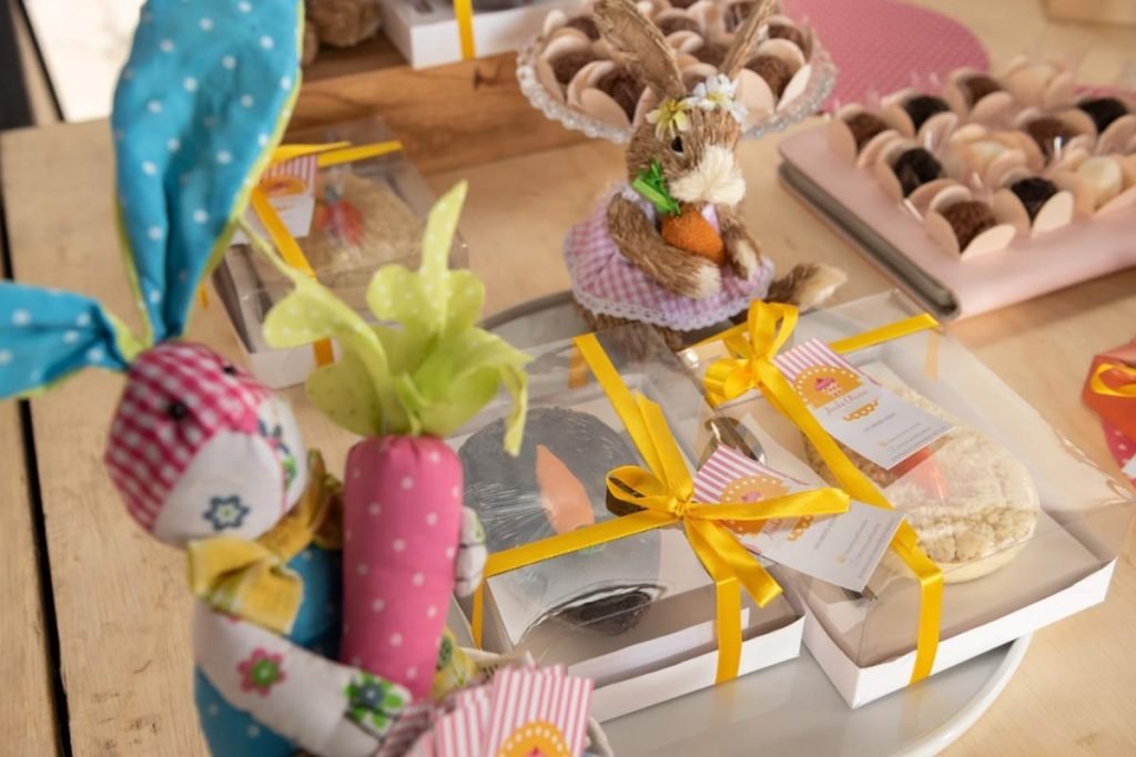 foto com coelhos de pelucia e caixas com ovos de pascoa de colher