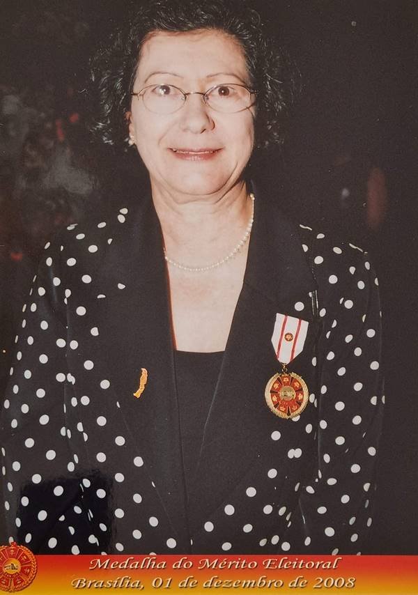 Fotografia colorida de mulher com medalha no peito