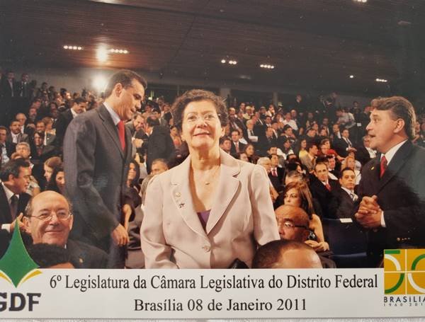 Fotografia colorida de mulher com plateia ao fundo
