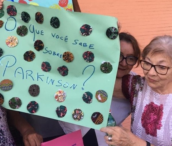 duas mulheres idosas seguram um cartaz da cor verde