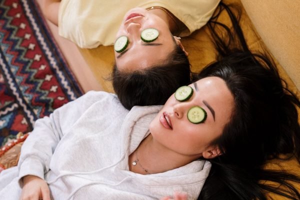 Duas mulheres deitadas com pepino nos olhos