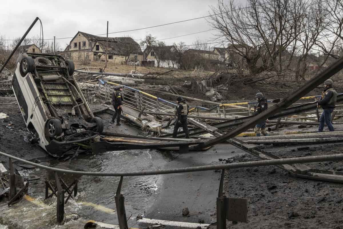 Membros das forças armadas ucranianas atravessam uma ponte destruída perto da linha de frente em meio a combates em Bucha e Irpin em 3 de março de 2022 em Irpin, Ucrânia.