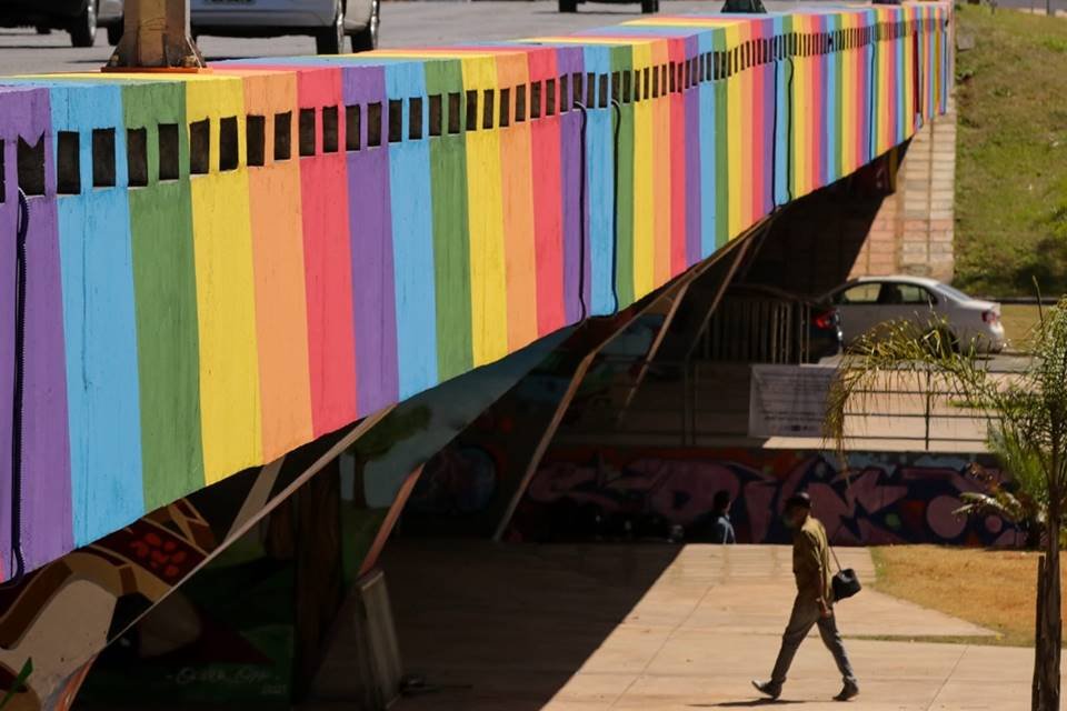 Pintura de arco-íris no viaduto da Galeria dos Estados com destaque para pedestres que passam embaixo - Metrópoles