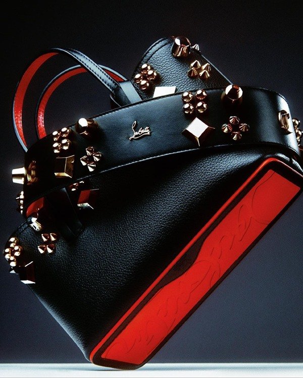 Bolsa preta com detalhes vermelhos e dourados da marca Louboutin