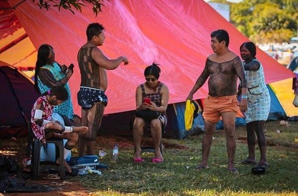 Foto colorida de indígenas no acampamento