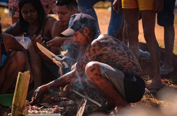Foto colorida de indígena no acampamento