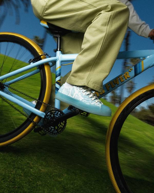 Tênis azul com estampa de cobra em pedal de bicicleta