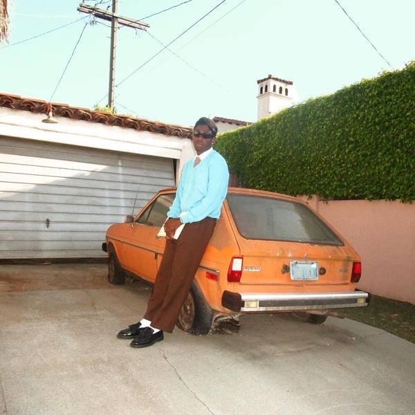 Rapper Tayler, The Creator encostado em carro laranja
