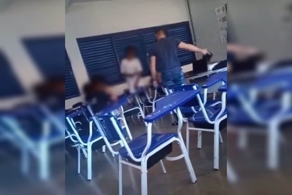 Carteiras azuis em sala de aula e alunos ao fundo