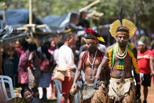 Indígenas trajados com adereços de sua etnia caminham em acampamento Terra Livre, no Eixo Monumental - Metrópoles