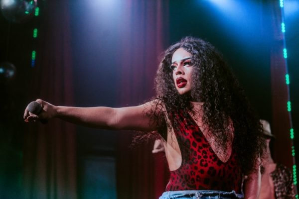 A artista e drag queen Gloria Groove na Victoria Haus, casa de shows voltados para o público LGBTQIA+ do DF. Na foto, ela aparece de perfil, segura um microfone com braço estendido - Metrópoles