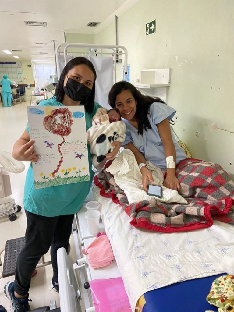 fotografia colorida de mulher ao lado de enfermeira obstetra