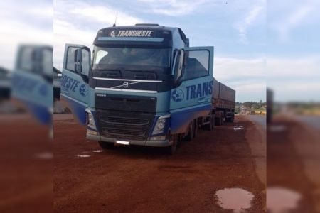 foto de um caminhão azul estacionado em uma estrada de terra