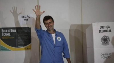 Marcelo Freixo, do PSOL, levanta a palma da mão aberta depois de sair de cabine de votação, acenando para jornalistas - Metrópoles