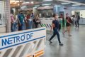 Estação do metrô, imagem composta por pessoas aleatórias, passando perto de sinalizações - Metrópoles