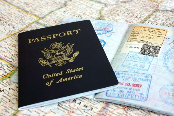 foto de um passaporte dos Estados Unidos em cima de um visto e a ilustração de um mapa