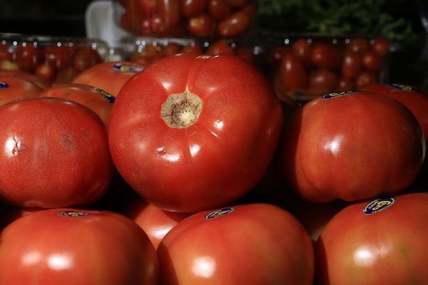 Tomates caqui vermelhos em exposição num supermercado - Metrópoles