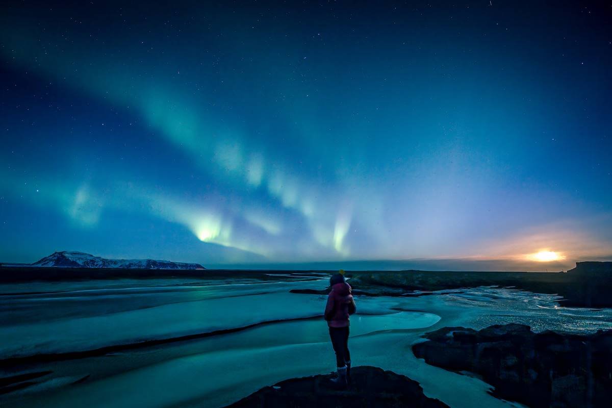 Pessoa observa aurora boreal azulada na Islândia - Metrópoles