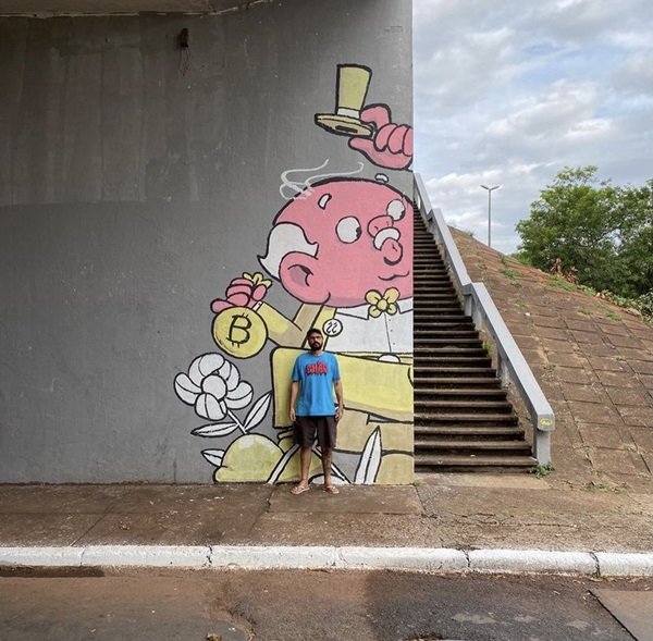 mural com ilustração de renato no centro de brasília e artista em pé em frente