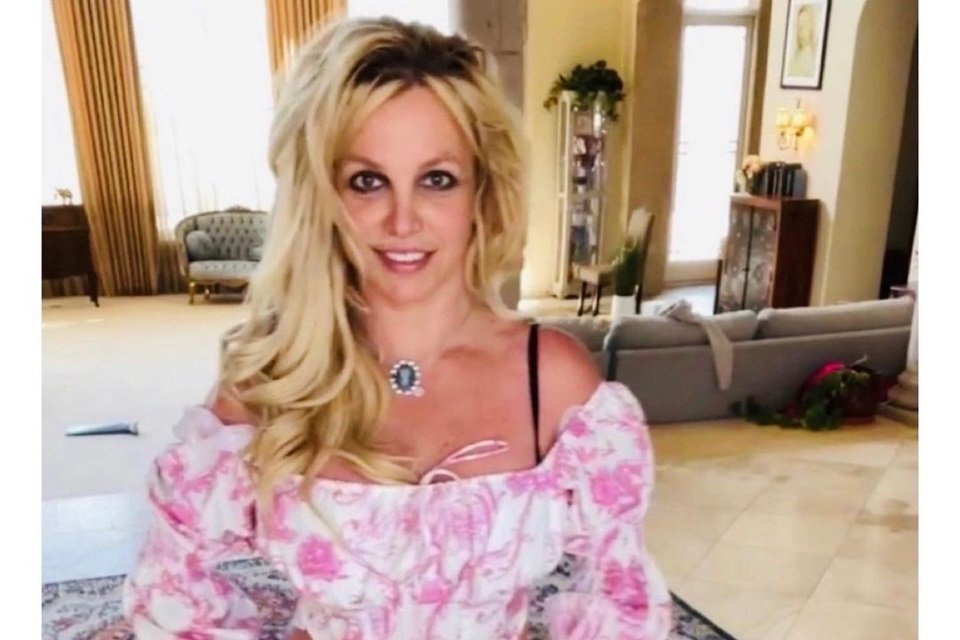 Britney Spears com look florido em branco e rosa dentro de casa - Metrópoles