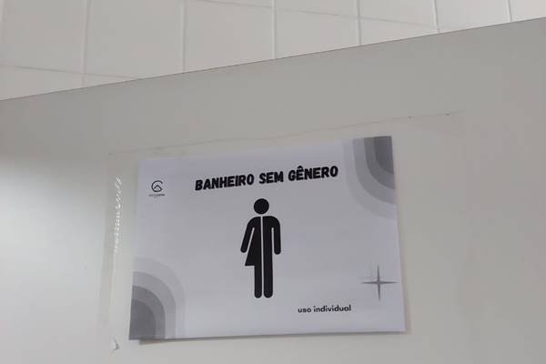 Fotografia colorida de um cartaz que identifica banheiro