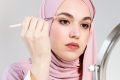 Mulher de hijab fazendo maquiagem em rosto