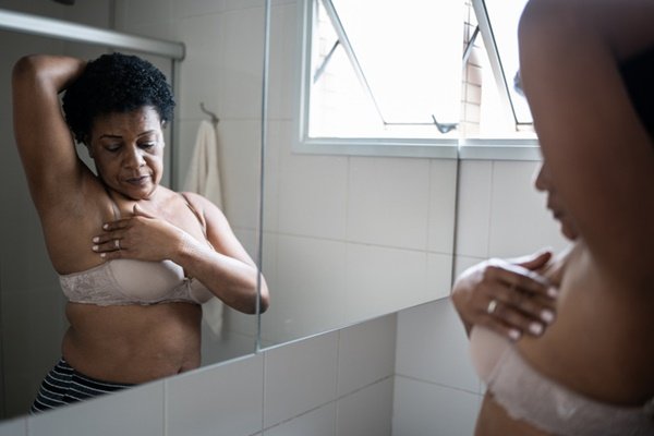 Woman touching breast cancer screening - Metropolis