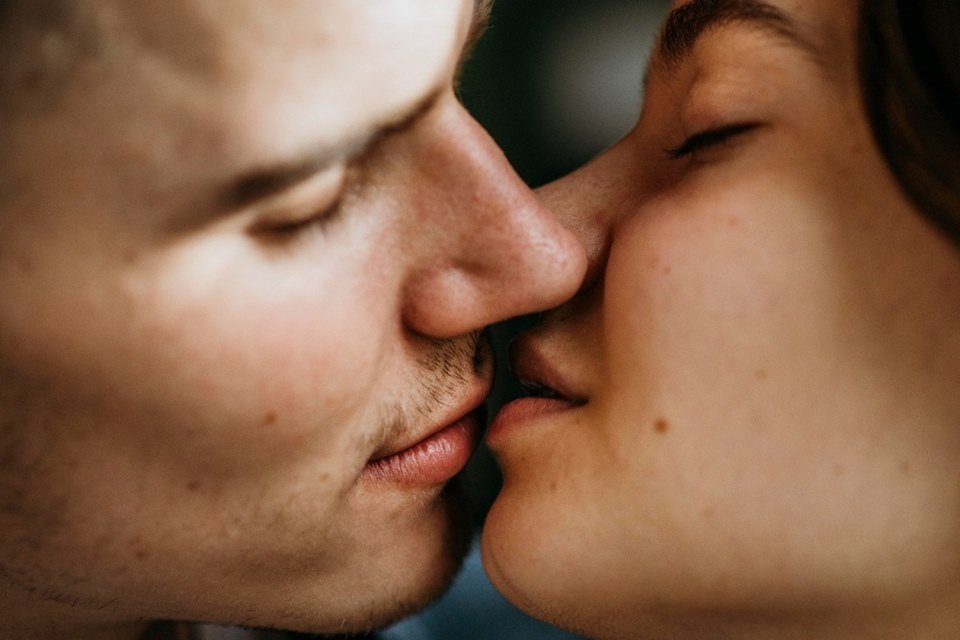 Um homem e uma mulher branca se beijando