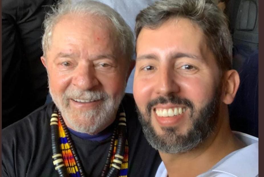 Lula tira selfie com o pré-candidato e deputado distrital Leandro Grasss, no acampamento indígena Terra Livre. Ambos sorriem - Metrópoles