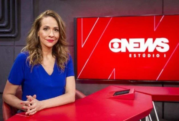 Maria Beltrão, jornalista e apresentadora.  Ela tem cabelos claros e usa roupa azul - Metrópoles