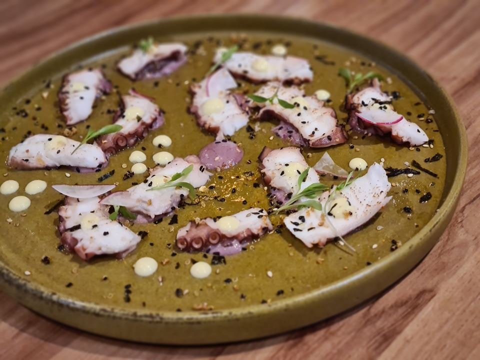 Polvo cozido e grelhado, guarnecido por tartar de azeitonas pretas, guacamole e furikake, prato do restaurante Kinjo - Metrópoles