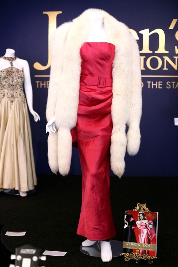 Na imagem com cor, manequim com o longo vestido rosa sob cachecol branco usado por Madonna no clipe de Material Girl
