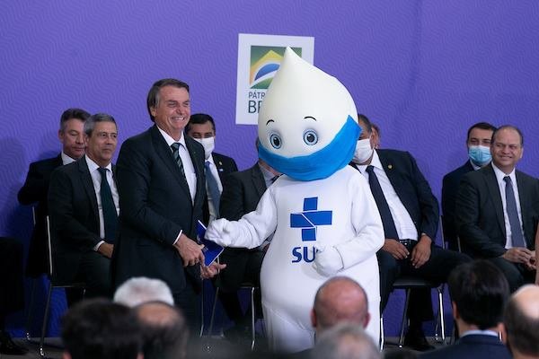 Foto colorida do presidente Jair Bolsonaro ao lado do Zé Gotinha em cerimônia do plano de vacinação no Brasil contra a Covid-19