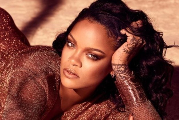 Rihanna, cantora e atriz internacional.  Ela tem pele negra, cabelos longos, escuros e tem olhos claros- Metrópoles