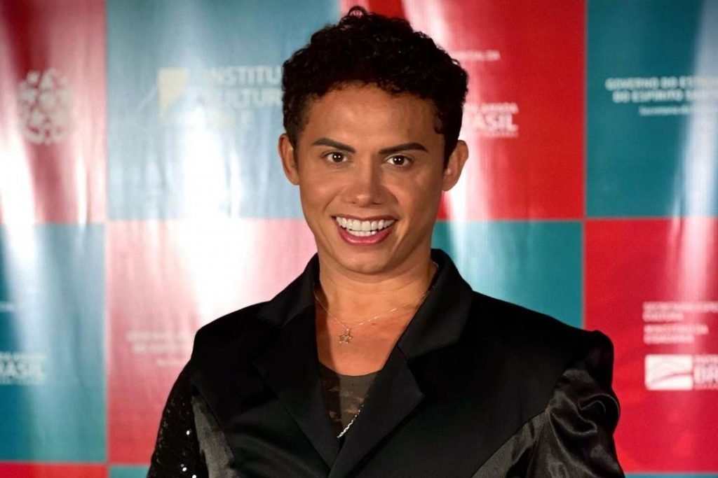 Silvero Pereira sorrindo de terno preto - Metrópoles