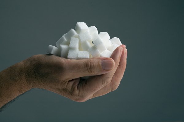 A hand holds several sugar cubes - metropolises