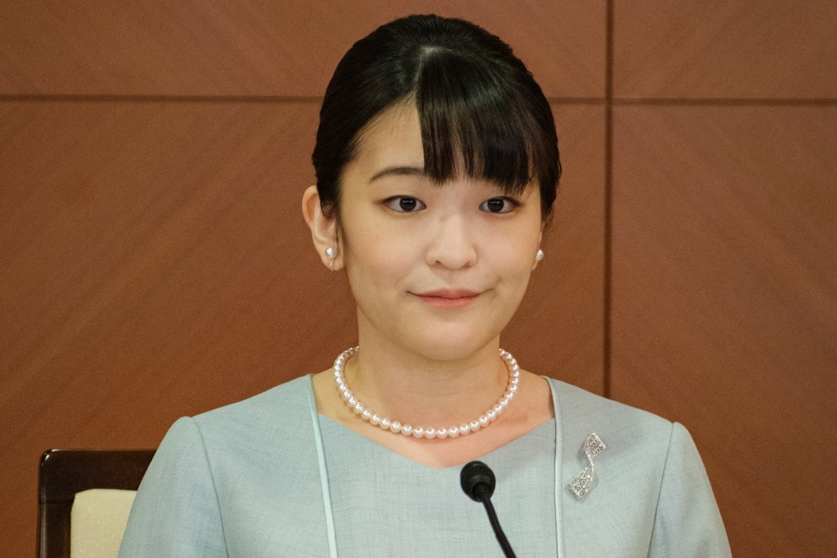 A ex-princesa Mako do Japão, destituida da realeza após casamento com plebeu. Ela usa colar de perolas, vestido azul claro e tem cabelo preto e liso - Metrópoles