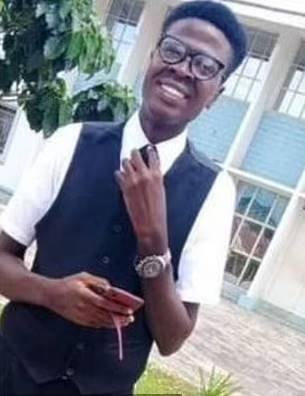 O jovem universitário Sule Ambrose sorri para foto, usando colete e gravata. Ele morreu em encenação da paixão de Cristo na Nigéria - Metrópoles